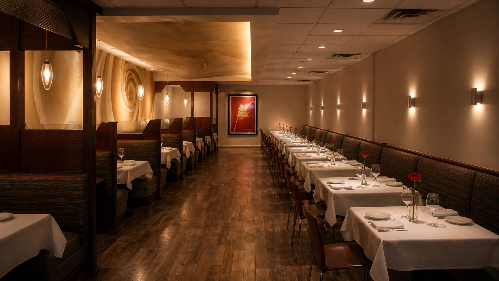 The far wall of the dining room, holding a large cream-and-beige mural that curls like a slow wave or a half-moon, dramatically lit from above.