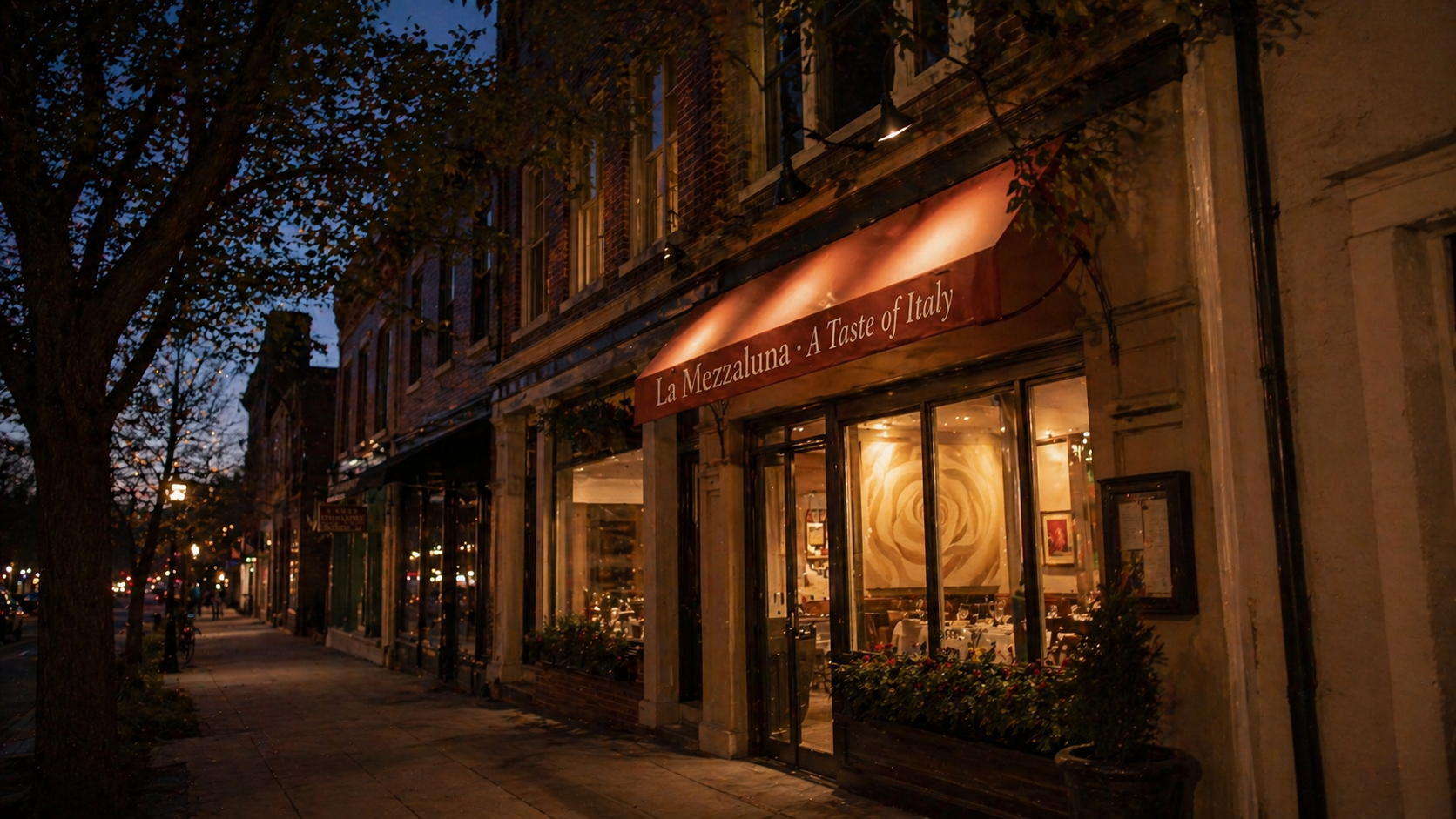 The block on Witherspoon Street looking north — La Mezzaluna's coral awning glowing under streetlamps and trees.